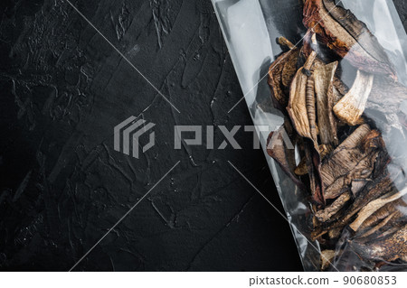 Dried wild mushrooms, on black background, in plastic pack, top view flat lay , with space for text copyspace Dried wild mushrooms, on black background, in plastic pack, top view flat lay , with space for text copyspace 90680853