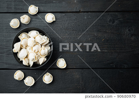 Frozen tortellini in black bowl, on black wooden table background , top view flat lay , with copyspace  and space for text 90680970