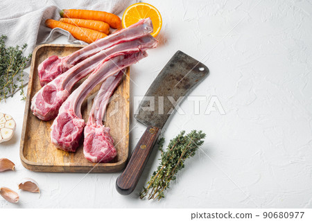 Raw Lamb Filets on bone, with ingredients carrot orange, herbs, and old butcher cleaver knife, on white stone background , with copyspace and space for text Raw Lamb Filets on bone, with ingredients carrot orange, herbs, and old butcher cleaver knife, on white stone background , with copyspace and space for text 90680977