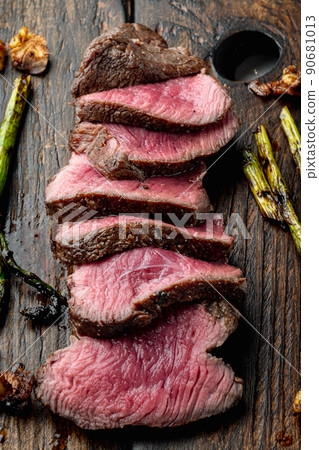 Grilled fillet mignon beef steak, with onion and asparagus, on wooden serving board 90681013
