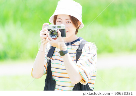 Woman with a camera in the park 90688381