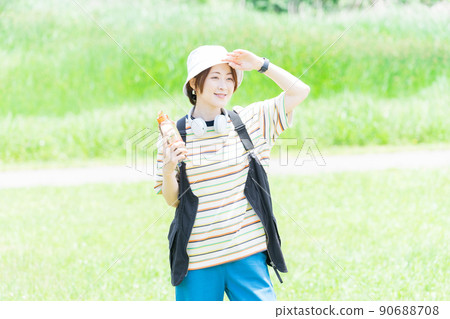 A woman taking a walk in the park with a water bottle A woman taking a walk in the park with a water bottle 90688708