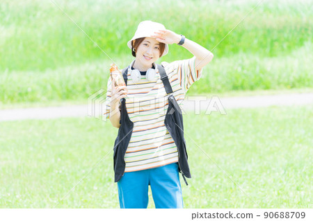A woman taking a walk in the park with a water bottle 90688709