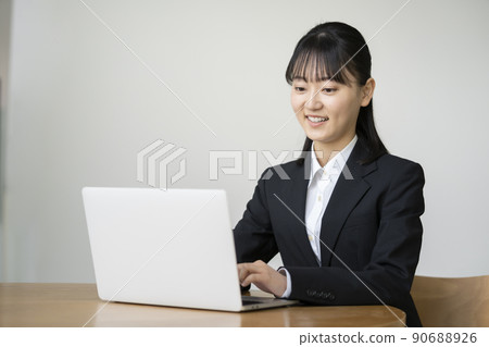 一個穿著西裝的年輕女人走向電腦 一個穿著西裝的年輕女人走向電腦 90688926