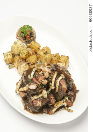 stewed beef short ribs and mushrooms in gravy with roast potatoes stewed beef short ribs and mushrooms in gravy with roast potatoes 90688927