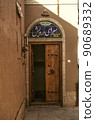Entrance door on the corner of one of the ancient streets of the old adobe city of Yazd 90689332