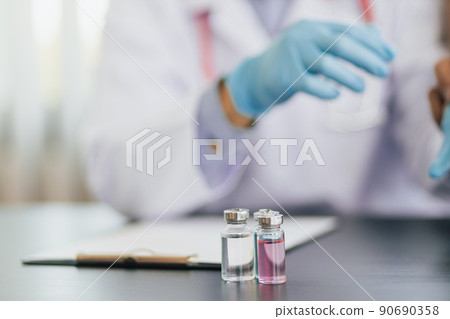 Close up holding a bottle of medicine or vaccine. Concept of medicine and disease prevention. Close up holding a bottle of medicine or vaccine. Concept of medicine and disease prevention. 90690358