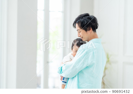一個抱著哭泣的嬰兒放鬆的男人。 一個抱著哭泣的嬰兒放鬆的男人。 90691432