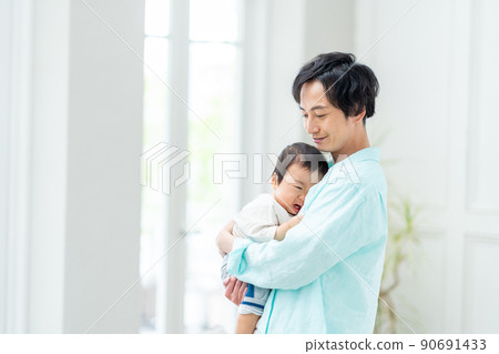 一個抱著哭泣的嬰兒放鬆的男人。 90691433