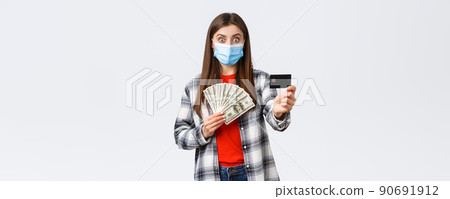 Money transfer, investment, covid-19 pandemic and working from home concept. Surprised young woman showing credit card and holding her cash savings, make bank account to save-up for trip Money transfer, investment, covid-19 pandemic and working from home concept. Surprised young woman showing credit card and holding her cash savings, make bank account to save-up for trip 90691912
