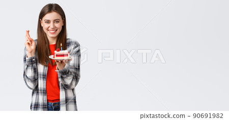 People lifestyle, holidays and celebration, emotions concept. Happy smiling pretty girl celebrate birthday, cross fingers good luck, blowing candle on b-day cake, having fun 90691982