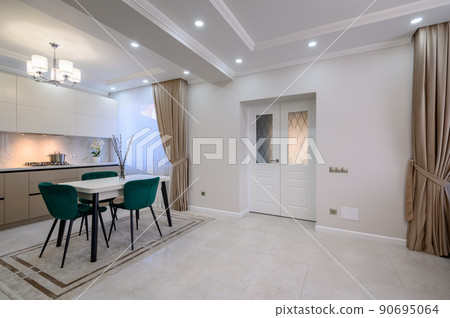 Modern white and beige large luxurious kitchen and dining table in studio apartment 90695064