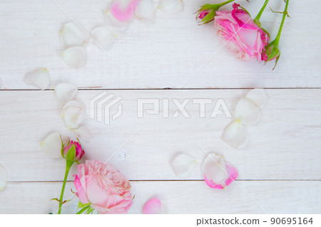 Roses and petals lie on a white wooden background forming an oval in the center for the text. High quality photo Roses and petals lie on a white wooden background forming an oval in the center for the text. High quality photo 90695164