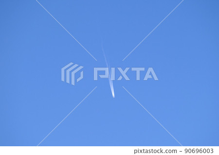 Distant passenger jet plane flying on high altitude on clear blue sky leaving white smoke trace of contrail behind. Air transportation concept. 90696003