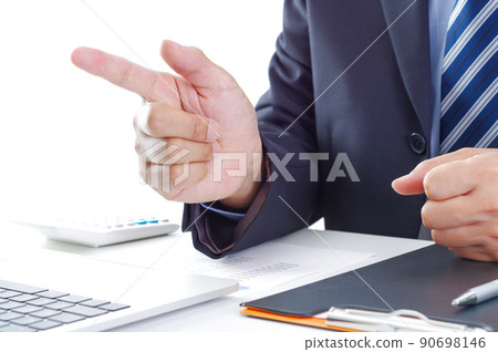 A man in a suit pointing in front of a computer 90698146