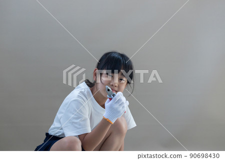 A state of an elementary school girl working with nippers at home in the summer A state of an elementary school girl working with nippers at home in the summer 90698430