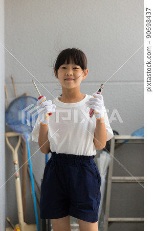 A state of an elementary school girl working with a tool box at home in the summer 90698437