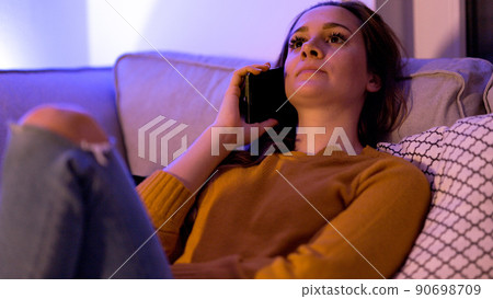 Young woman on the phone at home in her apartment 90698709