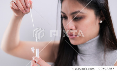 Young woman performs a Covid-19 antigen self-test 90698867