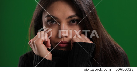 Young woman with a pretty face looks to the camera Young woman with a pretty face looks to the camera 90699325