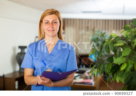 Portrait of female doctor wearing uniform and stethoscope with folder Portrait of female doctor wearing uniform and stethoscope with folder 90699327