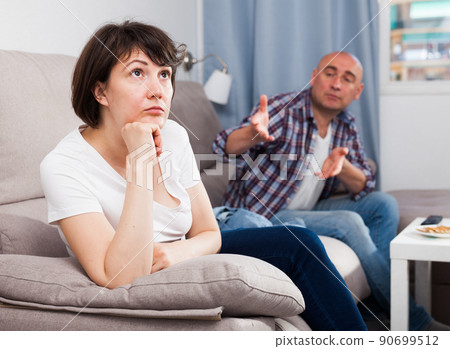 Sad family having difficulties in the living room at home Sad family having difficulties in the living room at home 90699512