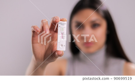 Woman holding a Corona Covid-19 Test with negative result 90699519