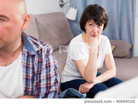 Unhappy mature man after quarrel, woman on background 90699520