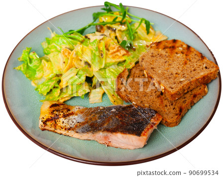 Delicious healthy dinner of baked salmon steak served with vegetable salad 90699534