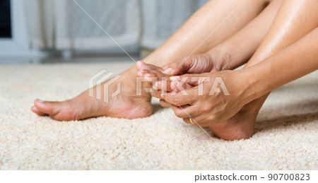 Asian woman holds her toe injury feeling pain her foot at home 90700823
