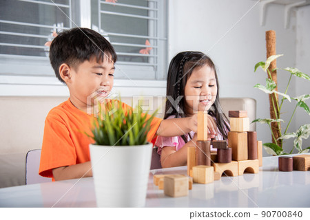 Children boy and girl playing with constructor wooden block building Children boy and girl playing with constructor wooden block building 90700840