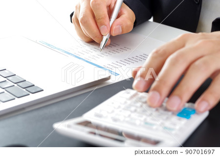 A man in a suit looking at documents and making calculations 90701697