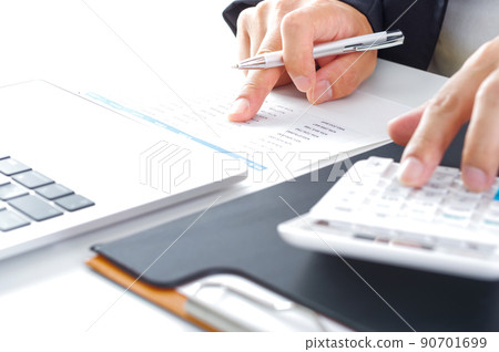 A man in a suit looking at documents and making calculations 90701699