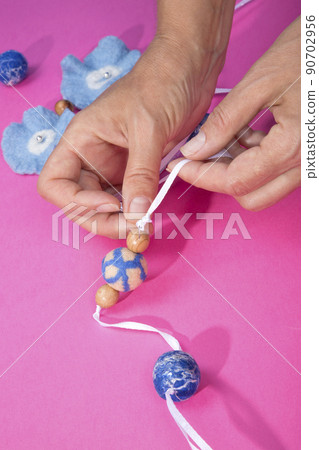 The female hands of the master assemble a handmade product from felted wool The female hands of the master assemble a handmade product from felted wool 90702956