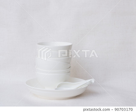 White ceramic bowl with spoon placed on white background 90703170