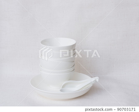 White ceramic bowl with spoon placed on white background 90703171
