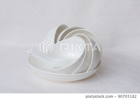 White ceramic bowl with spoon placed on white background 90703182