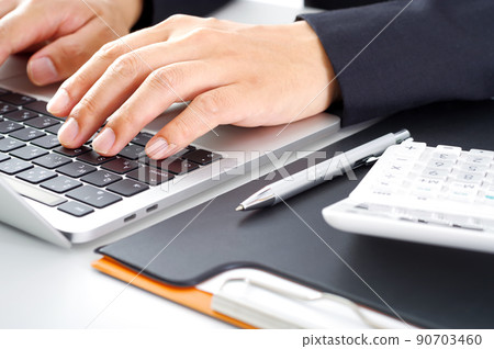 A man in a suit working on a computer A man in a suit working on a computer 90703460