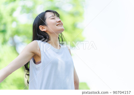 Japanese woman taking a deep breath in the green Japanese woman taking a deep breath in the green 90704157
