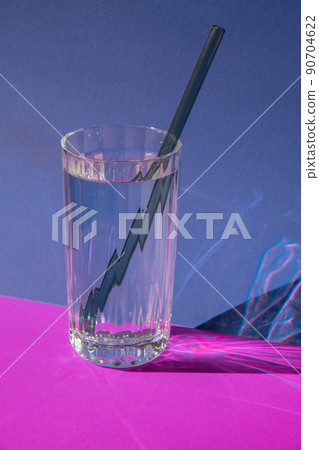 Reusable glass Straws in Glass with water on purple violet background Eco-Friendly Drinking Straw Set with cleaning brush. Zero waste, plastic free concept Reusable glass Straws in Glass with water on purple violet background Eco-Friendly Drinking Straw Set with cleaning brush. Zero waste, plastic free concept 90704622