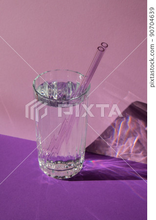 Reusable glass Straws in Glass with water on purple violet background Eco-Friendly Drinking Straw Set with cleaning brush. Zero waste, plastic free concept 90704639