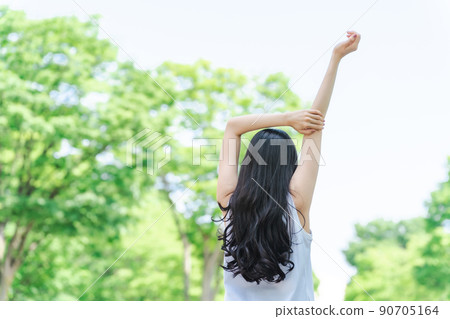 A woman stretching in the fresh green (without face) 90705164