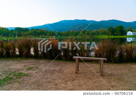 wood bench with beautiful lake at Chiang Mai with forested mountain and twilight sky wood bench with beautiful lake at Chiang Mai with forested mountain and twilight sky 90706158