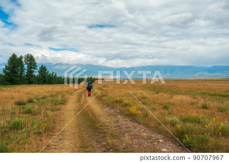 Solo hiking in the picturesque autumn mountain valley. Heavy climb in the mountains with a big backpack. Travel lifestyle, hiking hard track, adventure concept in autumn vacation. 90707967