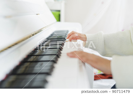 Girl playing the piano in the room Girl playing the piano in the room 90711479