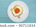 Appetizing fried eggs on a white plate set against a sky blue background ,with Clipping Path. 90711834
