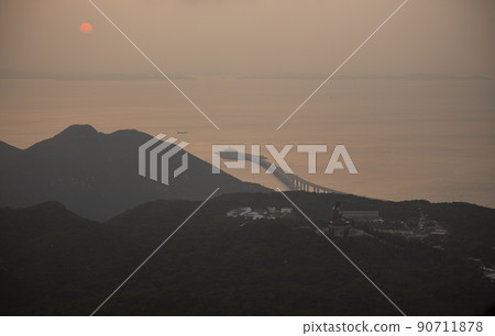 Hong Kong Zhuhai Macau bridge and big buddha view through the fog during sunset	 90711878