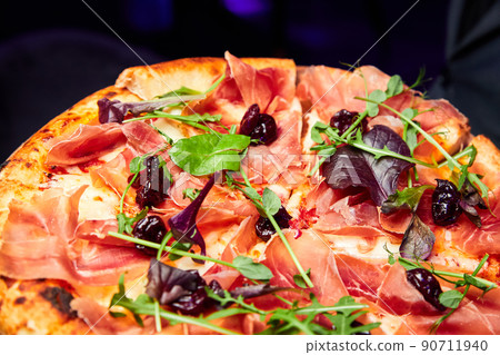 Pizza with ham and dried cherries. Close-up, selective focus 90711940