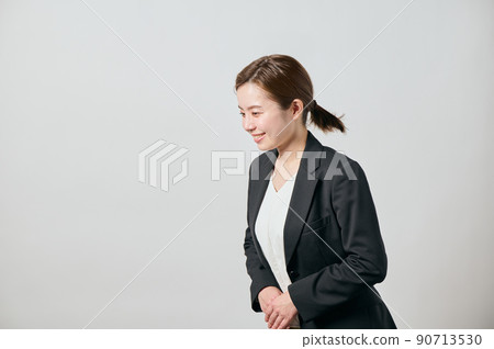 一個穿著夾克的女商人在前面鞠躬 一個穿著夾克的女商人在前面鞠躬 90713530