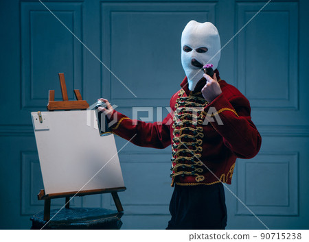 Young man, medieval hussar wearing white colors balaclava on dark blue background. Concept of comparison of eras, art, history. Creative collage. Young man, medieval hussar wearing white colors balaclava on dark blue background. Concept of comparison of eras, art, history. Creative collage. 90715238